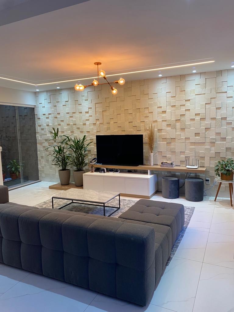 Sala contemporânea com parede revestida em mosaico de pedra branca